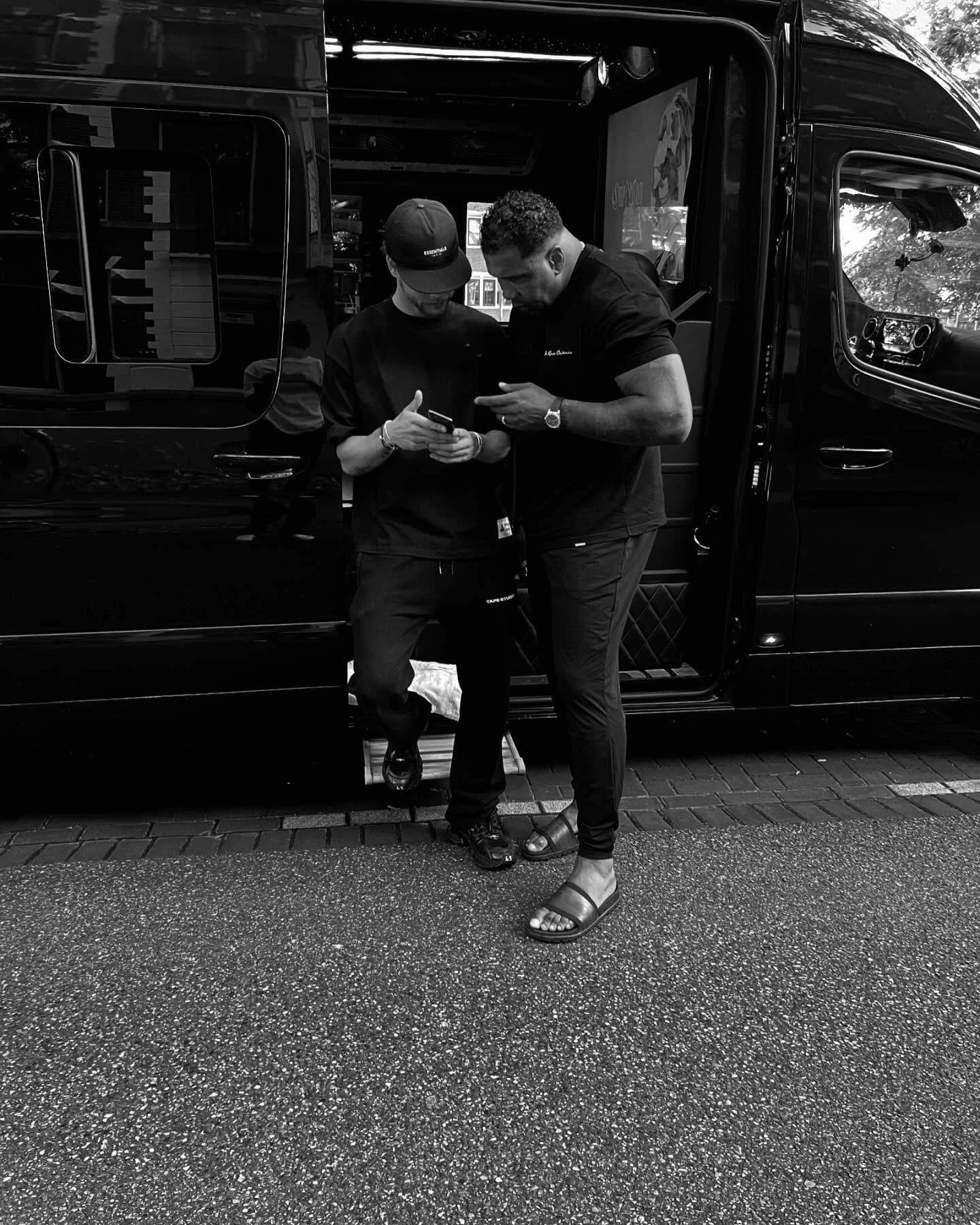 A black-and-white moment beside an open vehicle